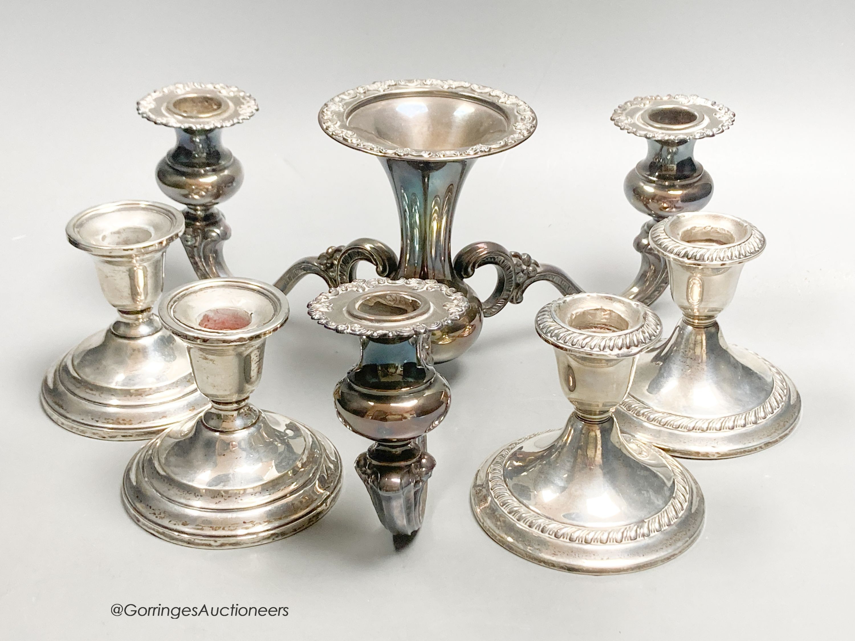 An American sterling three-branch candelabrum, 9.5oz and two pairs of similar dwarf candlesticks, 88mm, weighted.